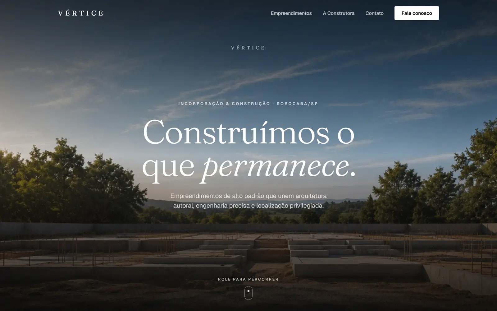 Hero do site da Construtora VÉRTICE: céu ao entardecer sobre fundação de obra, com o título Construímos o que permanece